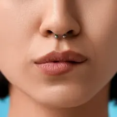 Zbliżenie na usta i nos z kolczykiem w septum. Delikatne, naturalne usta i srebrny kolczyk w przegrodzie nosowej.