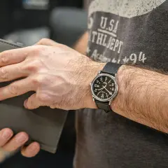 Mężczyzna z zegarkiem Timex, który jest znany z trwałości i przystępności. Klasyczny design, idealny na co dzień.