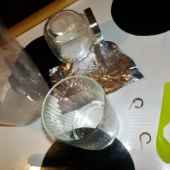 Przygotowania do czyszczenia złota folią aluminiową: szklanki, słoik, folia, łyżeczka i kolczyki.