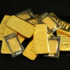 Kolekcja sztabek i opakowań ze **złoto próby 999**. Widać napisy "Fine Gold 999,9" i "1 KILO".