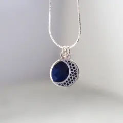 Srebrny wisiorek z lapis lazuli w kształcie półksiężyca. Dowiedz się, jak wyczyścić srebrną biżuterię z kamieniami, by zachować jej blask.