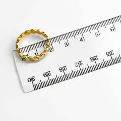 Złoty pierścionek z cyrkoniami obok linijki. Rozmiar 19 pierścionka ile to mm? Widać, że średnica wynosi ok. 19 mm.
