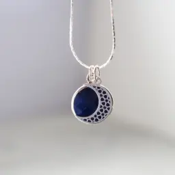 Srebrny wisiorek z lapis lazuli w kształcie półksiężyca. Dowiedz się, jak wyczyścić srebrną biżuterię z kamieniami, by zachować jej blask.