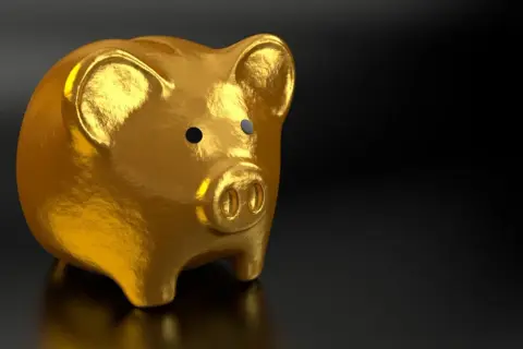 Złota skarbonka w kształcie świnki, błyszcząca jak złoty krugerrand 1 oz, symbolizuje oszczędności i bogactwo.