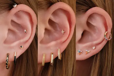Trzy uszy z różnymi kolczykami: na pierwszym widać piercing tragus, na drugim gwiazdkę, a na trzecim kolorowe kamyczki.