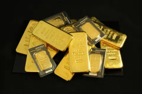 Kolekcja sztabek i opakowań ze **złoto próby 999**. Widać napisy "Fine Gold 999,9" i "1 KILO".