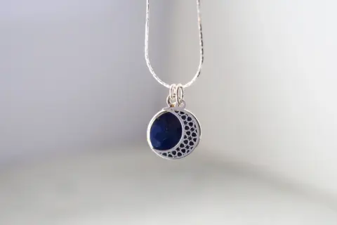 Srebrny wisiorek z lapis lazuli w kształcie półksiężyca. Dowiedz się, jak wyczyścić srebrną biżuterię z kamieniami, by zachować jej blask.