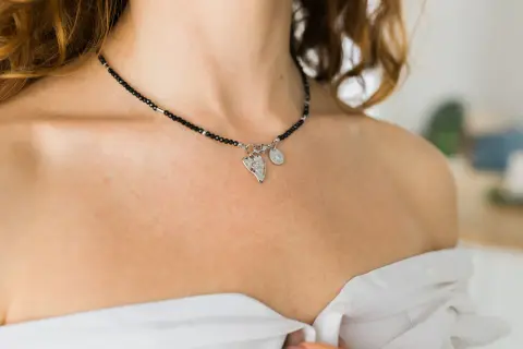 Czarny choker z zawieszkami, idealny dodatek do stylizacji. Co to jest choker? To krótki naszyjnik, który przylega do szyi.
