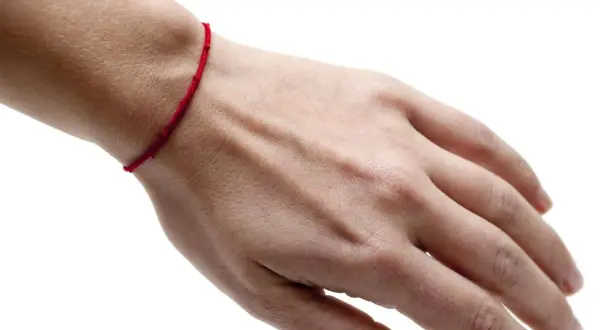 Czerwona nitka na nadgarstku symbolizuje ochronę i szczęście. To amulet, który ma odpędzać złe moce i przyciągać pozytywną energię.