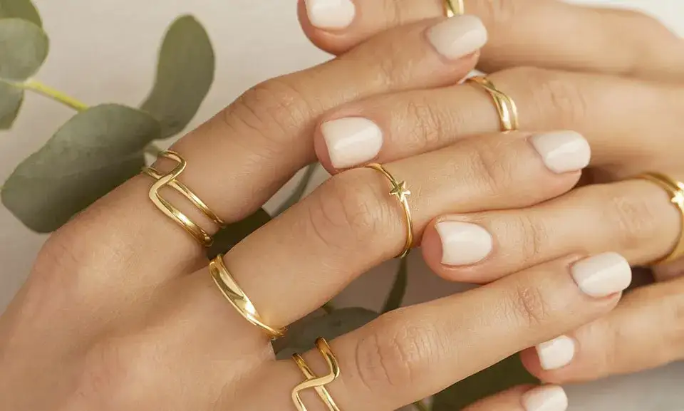 kobieta nosząca wiele pierścionków na jednym palcu, stacking rings