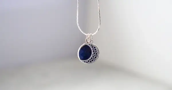 Srebrny wisiorek z lapis lazuli w kształcie półksiężyca. Dowiedz się, jak wyczyścić srebrną biżuterię z kamieniami, by zachować jej blask.
